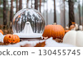 Halloween snow globe with a ghost inside placed among pumpkins in an autumn forest. 130455745