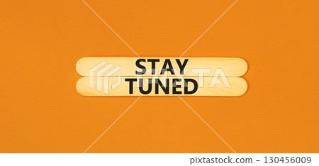 Stay tuned symbol. Concept words Stay tuned on beautiful wooden stick on a beautiful orange table orange background. Business, support, motivation, psychological and stay tuned concept. Copy space. 130456009