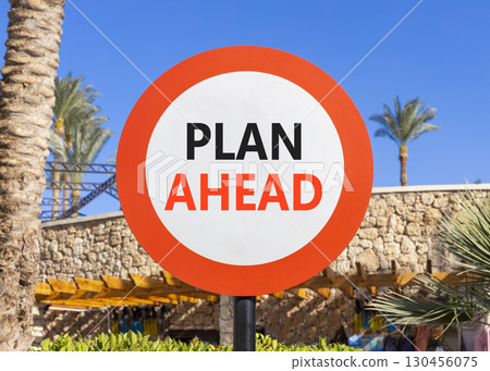 Plan ahead symbol. Concept word Plan ahead on beautiful red and white road sign. Beautiful palm tree and market blue sky background. Business plan ahead concept. Copy space. 130456075