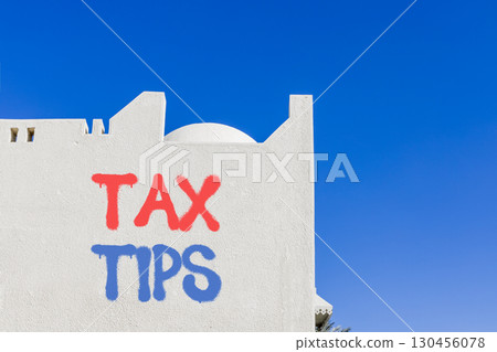 Tax tips symbol. Concept word Tax tips on beautiful white wall. Beautiful blue sky background. Business tax tips concept. Copy space. 130456078