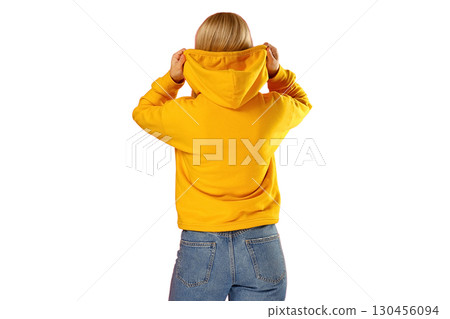 Female figure wearing a vibrant yellow hoodie, on white background 130456094