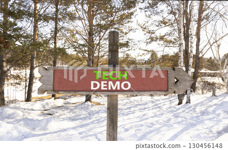 Tech demo symbol. Concept word Tech demo on beautiful wooden road sign. Beautiful snow winter forest background. Business tech demo concept. Copy space. 130456148