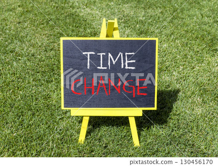 Time change symbol. Concept word Time change on beautiful black blackboard. Beautiful green grass lawn background. Black blackboard. Business time change concept. Copy space. Time change symbol. Concept word Time change on beautiful black blackboard. Beautiful green grass lawn background. Black blackboard. Business time change concept. Copy space. 130456170