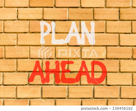 Plan ahead symbol. Concept word Plan ahead on beautiful brown brick wall. Beautiful brown brick wall background. Brick wall. Business plan ahead concept. Copy space. 130456182