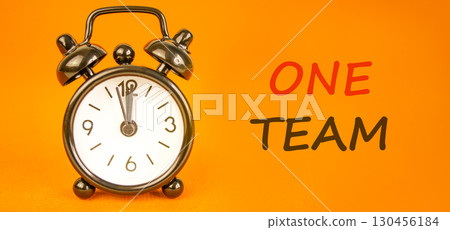 One team symbol. Concept word One team on beautiful orange paper. Beautiful black alarm clock. Beautiful orange paper background. Business one team concept. Copy space. One team symbol. Concept word One team on beautiful orange paper. Beautiful black alarm clock. Beautiful orange paper background. Business one team concept. Copy space. 130456184