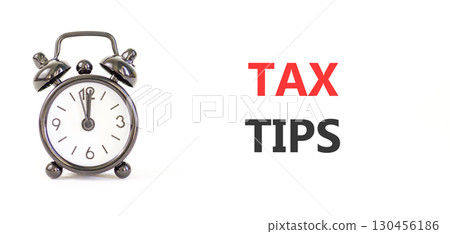 Tax tips symbol. Concept word Tax tips on beautiful white paper. Beautiful black alarm clock. Beautiful white paper background. Business tax tips concept. Copy space. Tax tips symbol. Concept word Tax tips on beautiful white paper. Beautiful black alarm clock. Beautiful white paper background. Business tax tips concept. Copy space. 130456186