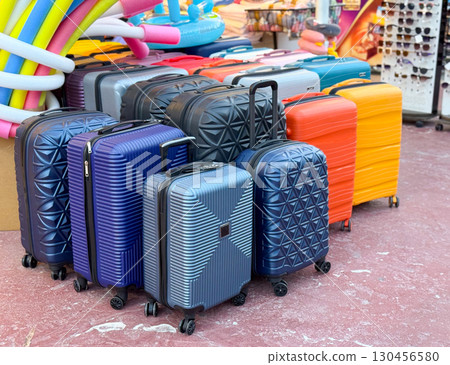 Colorful suitcases standing in store. Travel luggage, transport gear and tourism accessory for journey, vacation and modern storage with mobility and choice. Colorful suitcases standing in store. Travel luggage, transport gear and tourism accessory for journey, vacation and modern storage with mobility and choice. 130456580
