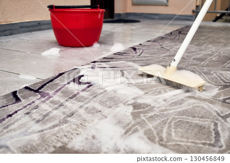 Rug cleaning with brush and soap foam close up 130456849