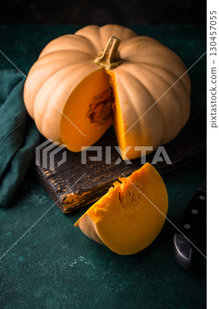 Raw fresh cut pumpkin on dark background 130457055
