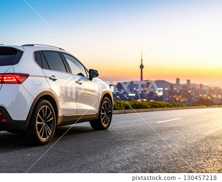 夕陽下，一輛汽車沿著海邊公路行駛 130457218