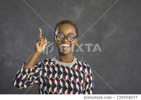 Black woman in crazy funny glasses pointing her finger up struck by a great idea Black woman in crazy funny glasses pointing her finger up struck by a great idea 130458077