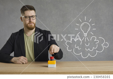 Young businessman pushes a red creativity button to launch an idea light bulb rocket 130458101