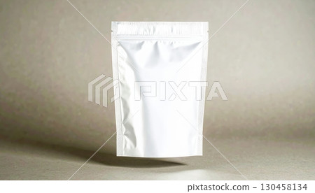 Close-up of a plain white resealable plastic pouch standing upright on a neutral surface with a subtle background, suitable for packaging or storage purposes 130458134