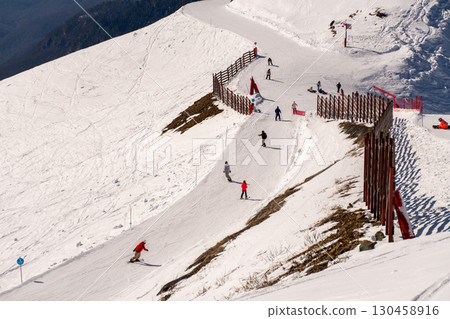 Skiers, Mountain, Resort: Winter Sports, Snowy Slopes, People Skiing Safely Downhill. Skiers, Mountain, Resort: Winter Sports, Snowy Slopes, People Skiing Safely Downhill. 130458916