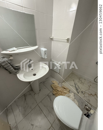 Small bathroom interior with sink, toilet and mirror in bright light. Hygiene, facility, daily usage and essential element of accommodation and personal care environment. 130459662