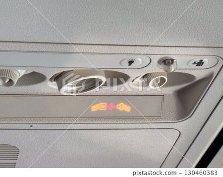 Closeup of airplane cabin panel with air vents and light controls. Passenger service and aviation engineering. Closeup of airplane cabin panel with air vents and light controls. Passenger service and aviation engineering. 130460383