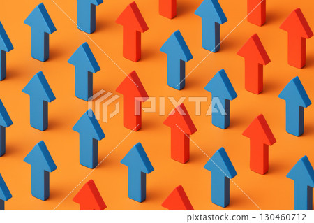 Bright orange surface features blue and red arrows arranged in geometric rows, symbolizing business growth and direction 130460712