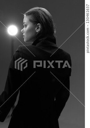 Black and white portrait of a thoughtful woman with braided hair wearing a dark coat in studio lighting. Black and white portrait of a thoughtful woman with braided hair wearing a dark coat in studio lighting. 130461637