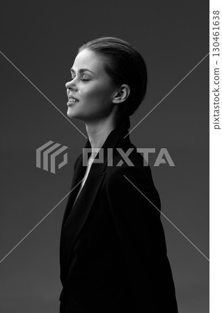 Black and white portrait of a calm woman in a blazer with closed eyes and serene expression 130461638