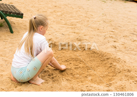 8 year old girl playing with sand on the beach 8 year old girl playing with sand on the beach 130461806