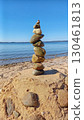On the beach, on the sand, pebbles are placed on top of each other 130461813