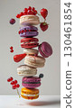 A stack of colorful macarons is suspended in mid-air, surrounded by floating redcurrants and strawberries. The levitation effect adds a surreal, magical touch AI generated 130461854