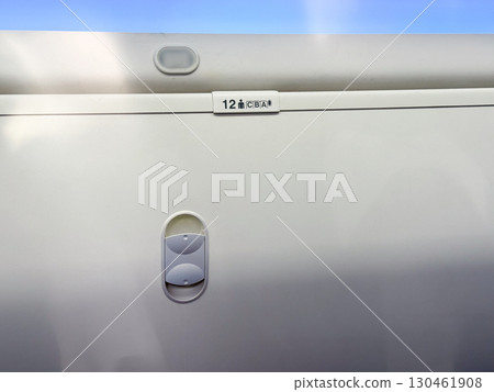 Closed overhead locker inside airplane cabin with seat number label visible. Aviation storage, travel organization and air transport interior design element. Closed overhead locker inside airplane cabin with seat number label visible. Aviation storage, travel organization and air transport interior design element. 130461908