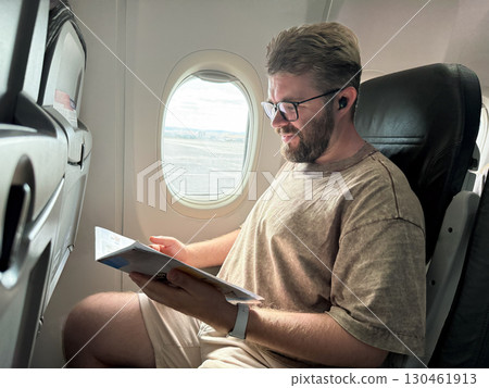 Passenger sitting by the airplane window seat during boarding. Travel experience, journey, and lifestyle in air transport. 130461913