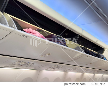 Overhead luggage compartments and cabin ceiling inside a passenger airplane. Travel, aviation, and the practical design of space in modern aircraft cabins. Overhead luggage compartments and cabin ceiling inside a passenger airplane. Travel, aviation, and the practical design of space in modern aircraft cabins. 130461934