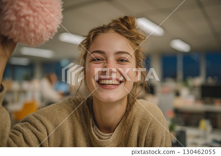 Joyful moment in an open office as a woman plays with a plush toy Joyful moment in an open office as a woman plays with a plush toy 130462055