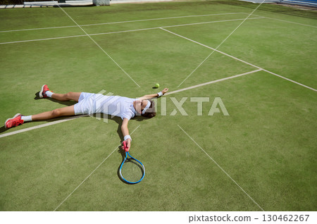 Tennis Player Sprawled on Court After Intense Match on Grass Surface 130462267