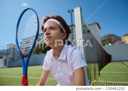 Focused Young Tennis Player Ready for Action Outdoors on Sunny Day 130462282