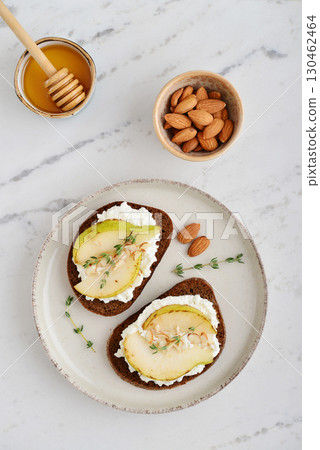 Bruschetta with cream cheese, honey, pear, thyme 130462464
