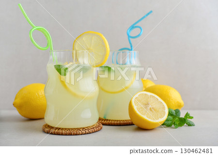 Two glasses of homemade lemonade with drinking straws 130462481