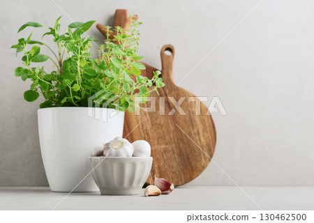 Fresh seasoning herbs in flower pot, two wooden cutting board and garlic Fresh seasoning herbs in flower pot, two wooden cutting board and garlic 130462500
