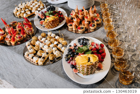 Elegant catering table with assorted canapes, fresh fruits and whiskey glasses Elegant catering table with assorted canapes, fresh fruits and whiskey glasses 130463019