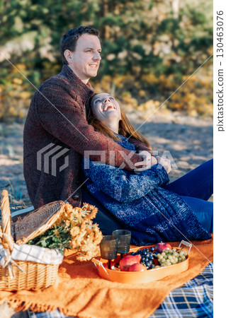 Portrait happy beautiful couple in love enjoying autumn picnic in autumn park. Vertical photo. High quality photo Portrait happy beautiful couple in love enjoying autumn picnic in autumn park. Vertical photo. High quality photo 130463076