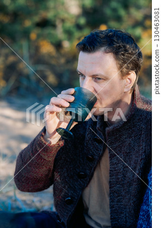 Male portrait. Beautiful young man with long dark hair on a sunny autumn day outdoors. Vertical photo. High quality photo 130463081