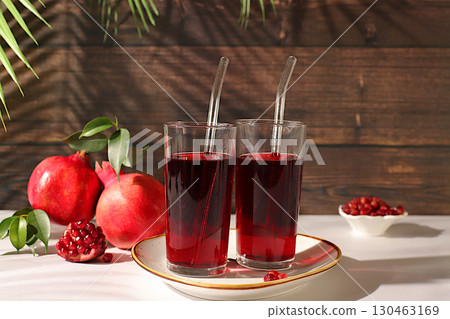 Pomegranate juice drink and ingredients, rich pomegranate drink on elegant sunny table, detox diet and weight loss concept, natural food for healthy lifestyle, source of vitamin C 130463169