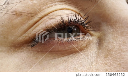 Focus on right green eye of attractive girl blinking and looking into camera. Portrait of upset female face. Sorrowful facial expression of young woman. Unhappy sight of beautiful lady. Close up Focus on right green eye of attractive girl blinking and looking into camera. Portrait of upset female face. Sorrowful facial expression of young woman. Unhappy sight of beautiful lady. Close up 130463232