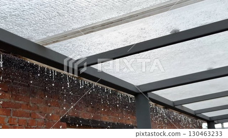Heavy rain drumming on the transparent plexiglass roof. Beautiful rainy scene on summer day. Concept of tranquility nature scene. Close up Slow motion 130463233