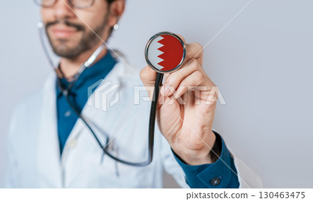 Doctor holding stethoscope with Bahrain flag. Bahrain health and care concept, Bahrain flag on stethoscope 130463475