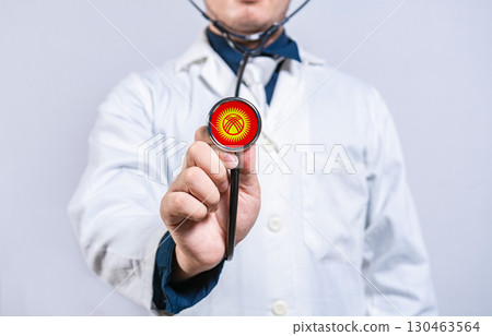 Doctor hands holding stethoscope with Kyrgyzstan flag. Kyrgyzstan health and care concept 130463564