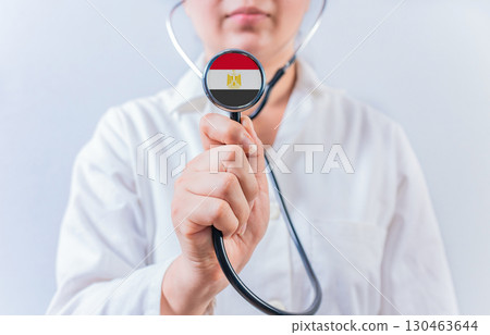 Female doctor holding stethoscope with Egypt flag. National health system of Egypt Female doctor holding stethoscope with Egypt flag. National health system of Egypt 130463644