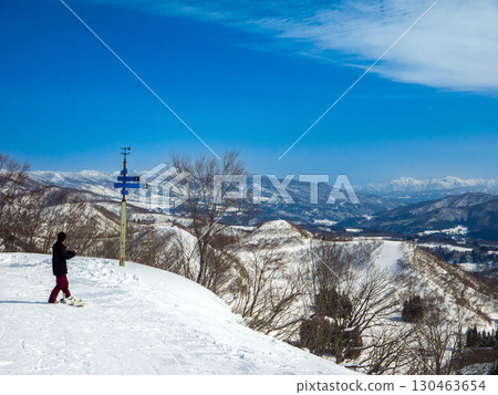 單板滑雪愛好者在滑雪場半山腰眺望廣闊的雪景(長野縣飯山市戶漾溫泉) 單板滑雪愛好者在滑雪場半山腰眺望廣闊的雪景(長野縣飯山市戶漾溫泉) 130463654