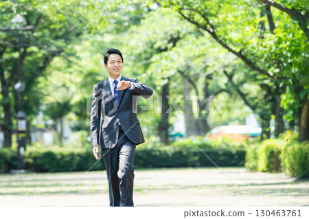走在新鮮的綠色的商人 130463761
