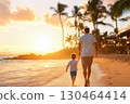 Father and son walking on tropical beach at sunset, enjoying serene view 130464414