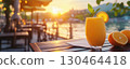 Refreshing orange smoothie on terrace at sunset, with scenic view 130464418