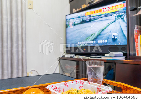 Watching typhoon news on TV 130464563