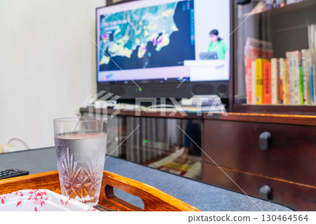 Watching typhoon news on TV 130464564